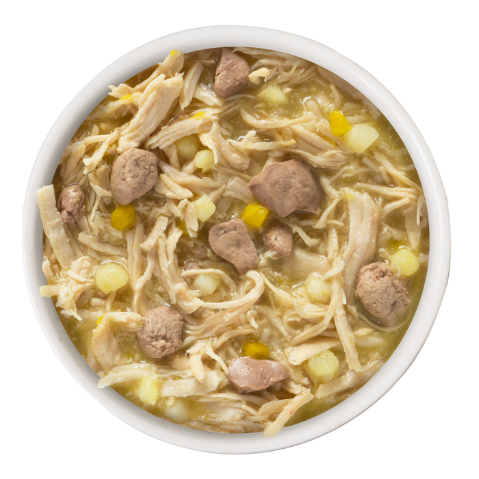 A bowl of Weruva Amazon Livin' filled with shredded chicken, meat chunks, corn, diced potatoes, and tender pumpkin in a thick broth, viewed from above.