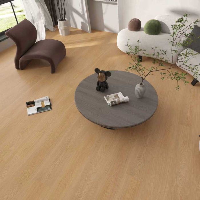 Modern living room with a round wooden coffee table, chair, and decorative items.