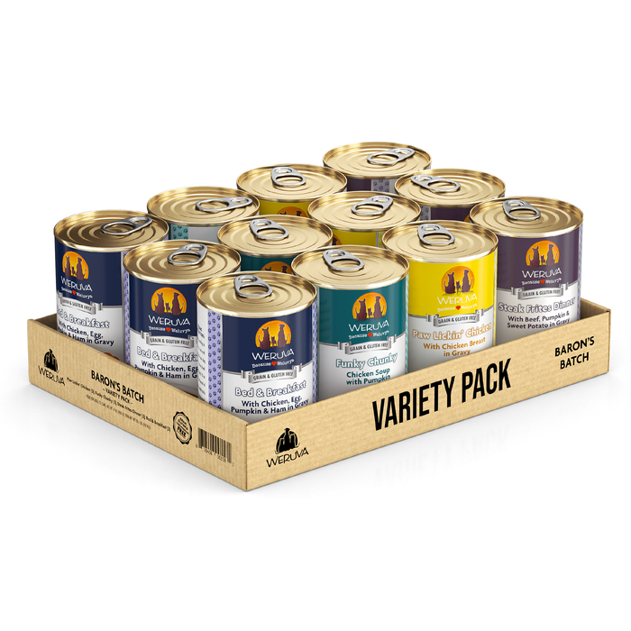 A Weruva Baron's Batch cardboard tray holds 12 wet dog food cans in assorted flavors, each with a gold lid and colorful label. The tray is marked "VARIETY PACK BARON'S BATCH" and promotes real ingredients.