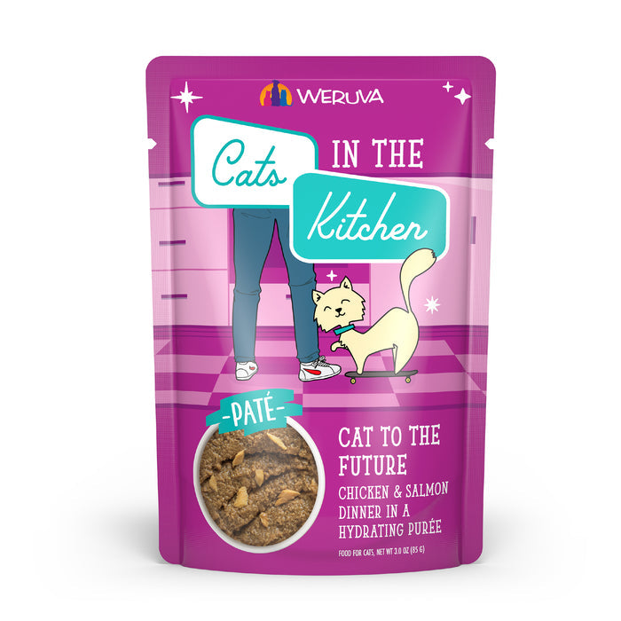 A pink pouch of Cats in the Kitchen Cat to The Future cat food features creamy paté with cage-free chicken and wild-caught salmon in purée. The package displays bright graphics with a cartoon cat and person.