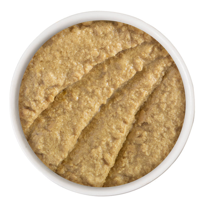 A white bowl filled with BFF Best Feline Friend Chicken & Turkey Tiptoe, a thick, light brown spread for cats, is shown from above with textured ridges on the surface.