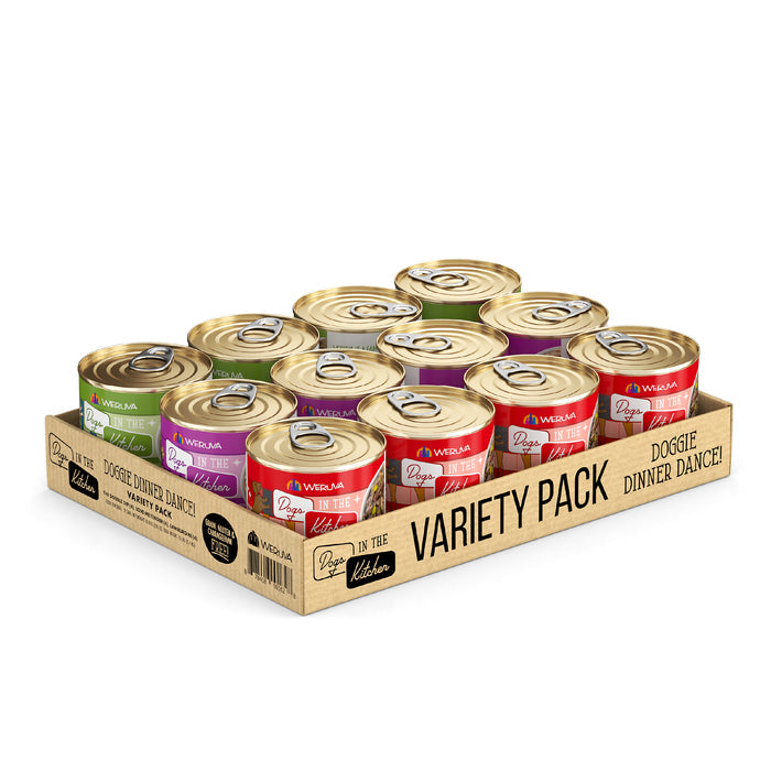A cardboard tray branded Dogs in the Kitchen holds 12 cans of Doggie Dinner Dance! dog food, each with a gold lid and colorful purple, green, and red labels.