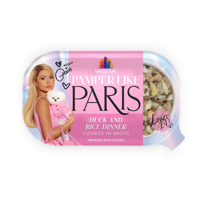 A Weruva Duck and Rice Dinner can features a pink label with a woman holding a white dog. Charming handwritten notes and hearts decorate the label, while a clear window reveals the indulgent dog food inside.