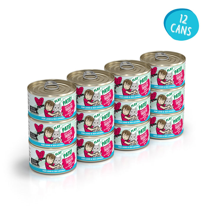 Twelve cans of BFF Best Feline Friend Duck & Tuna Trickster grain-free cat food are stacked in three rows of four. The white labels, featuring a cat and text, include a blue circle with “12 cans” in the top right corner.
