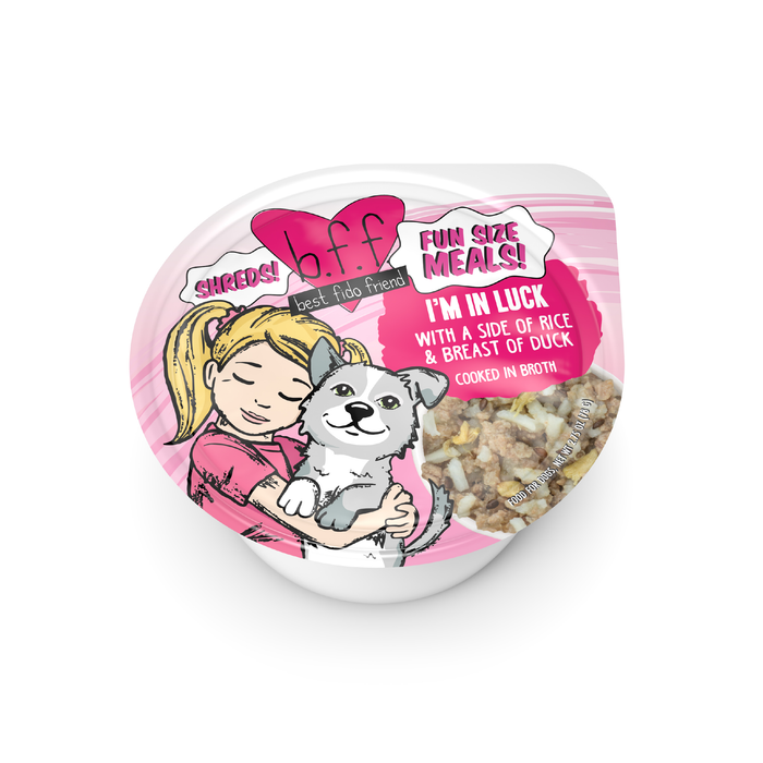 A small container of BFF Best Fido Friend pet food called "I'm In Luck" features a girl hugging a gray and white dog. The label highlights rice and duck breast treats cooked in broth with shredded food inside.