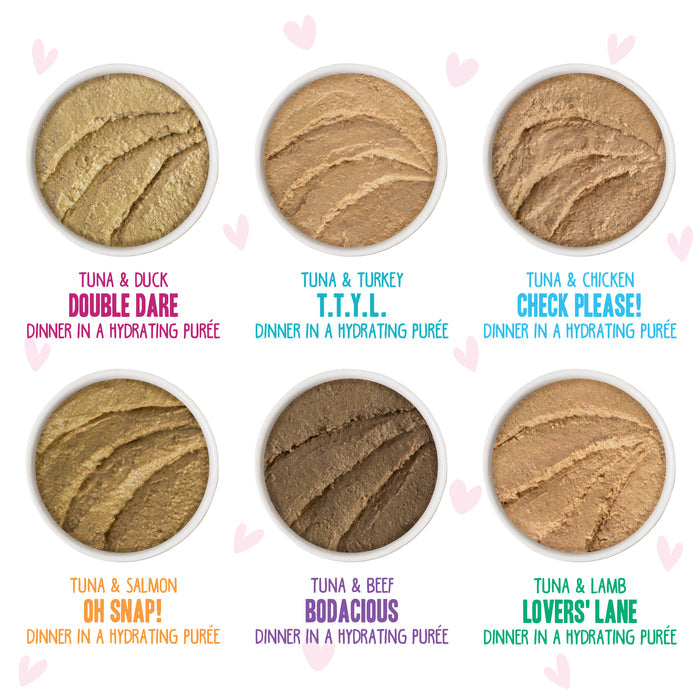 Six circular containers of BFF Best Feline Friend Pinky Promise Patés—creamy, grain-free hydrating purée treats in flavors like tuna & duck or tuna & lamb—are arranged on a white background with pink hearts, perfect for cats who love tuna paté.