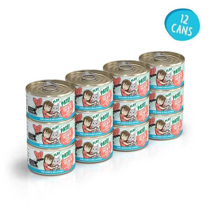 Twelve cans of BFF Best Feline Friend Salmon & Tuna Tuck Me In grain-free wet cat food, with girl and cat illustrations on the label that says “Paté for Land & Sea Lovers.” Blue circle highlights “12 cans.” Features tuna and wild-caught salmon.