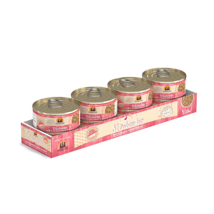 Four cans of Weruva Stewlander cat food sit in a pink and white tray, each can with a gold lid and pink label highlighting cage-free duck and omega-3s for your cat’s health.