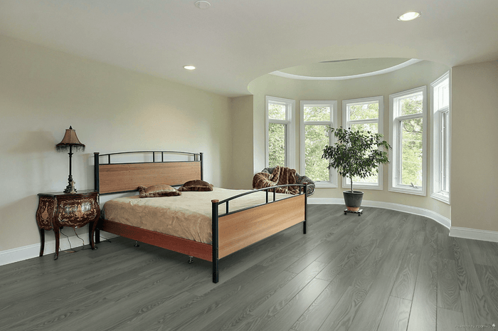 A modern bedroom which displays the beautiful look of Bar Harbor Toucan 8mm vinyl flooring.