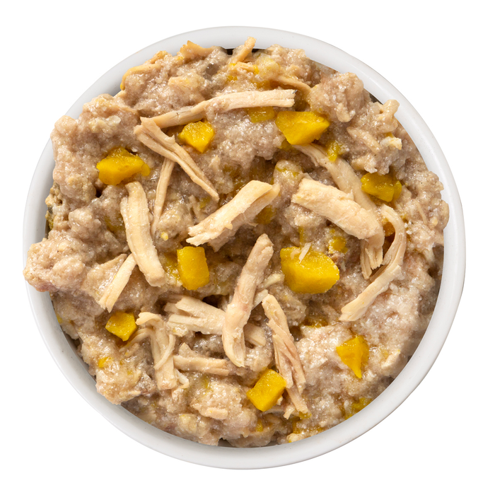 A white bowl filled with Weruva That's My Jam!—a chunky mix of grass-fed lamb, shredded meat, and yellow pumpkin—resembling pet food or a savory stew, set against a plain white background.