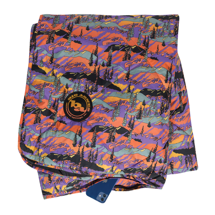 Colorful mountain-patterned towel with a brand logo on a white background
